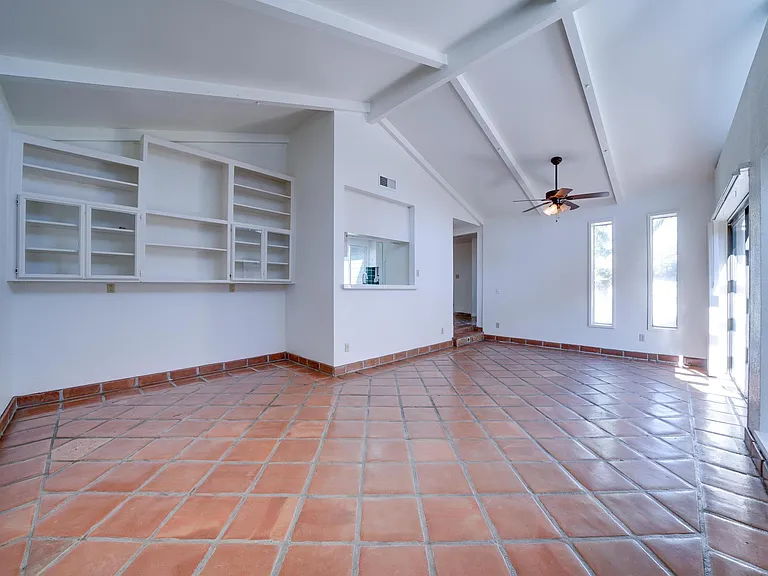 Another angle of the large living room/dining room space. Pre-built shelving located on western wall.