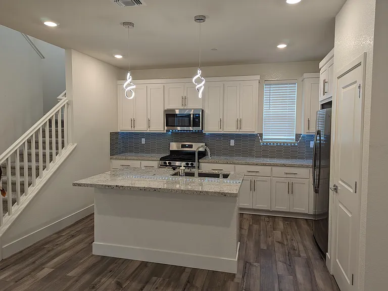 Kitchen with Pendant lights & light strips below the cabinets for premium looking.