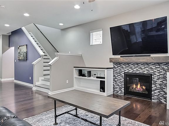 Past the stairwell, you enter into the family room with built in book shelves, cozy gas fireplace with upgraded mosaic tile.