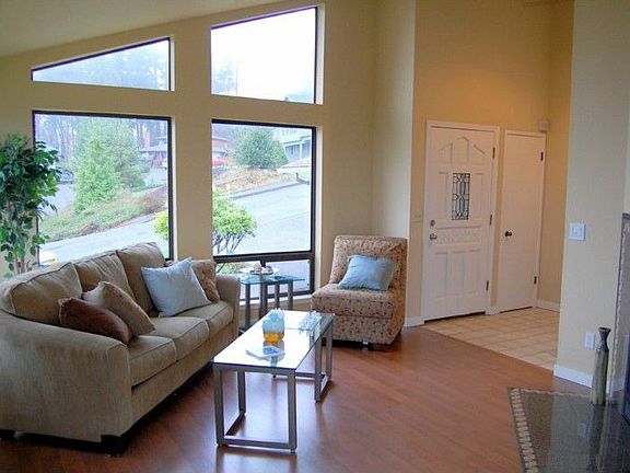 Wood laminate flooring, vaulted ceilings, a cozy gas fireplace and oversized view windows, create a 