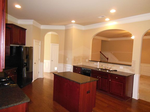 Kitchen w/ granite countertops, island, and breakfast bar open to family room