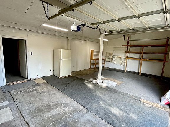View from garage door: Spacious 2-car garage (refrigerator, work bench, and shelving unit included)
