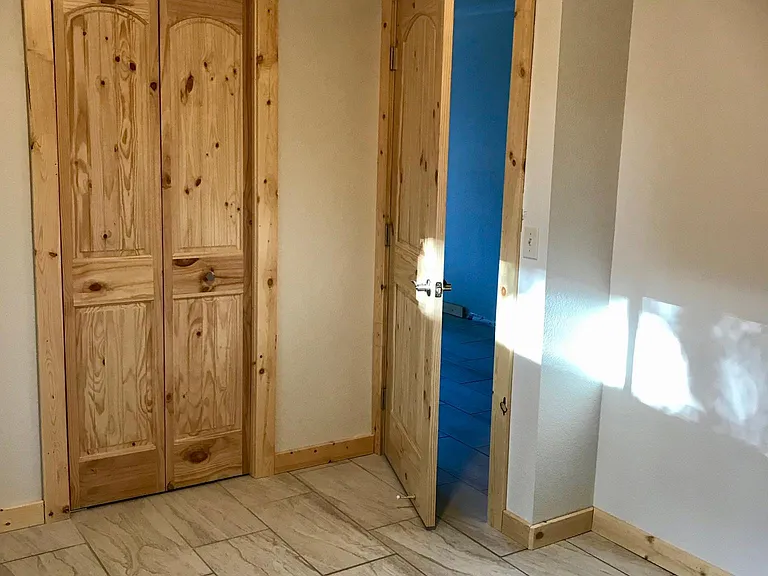 Bedroom 2. Custom solid pine entry and cabinet doors and trim. Custom tile floors. Nice bright natural light.