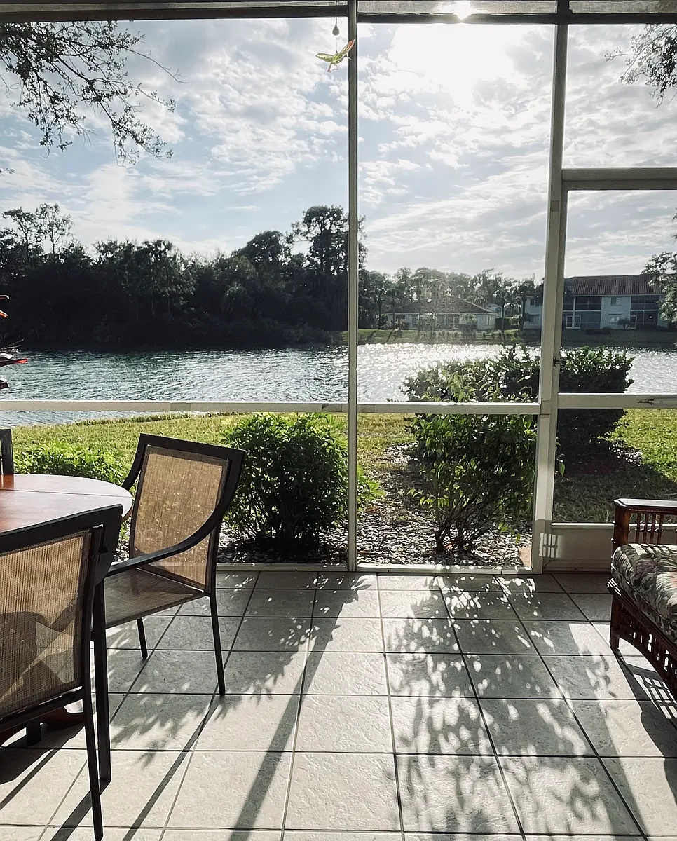 Private patio rattan couch, eating area for coffee, breakfast and wine overlooking small Fl lake - 695 Luisa Ln #1