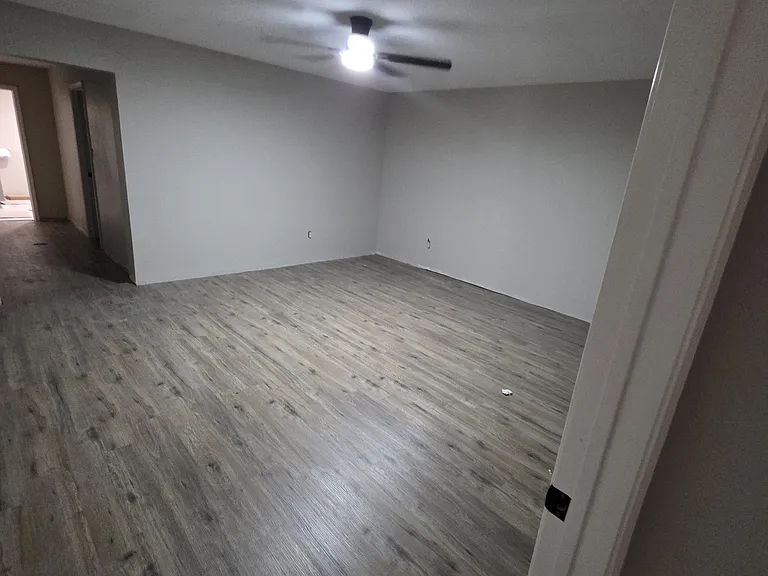 Primary bedroom with new flooring and ceiling fan.