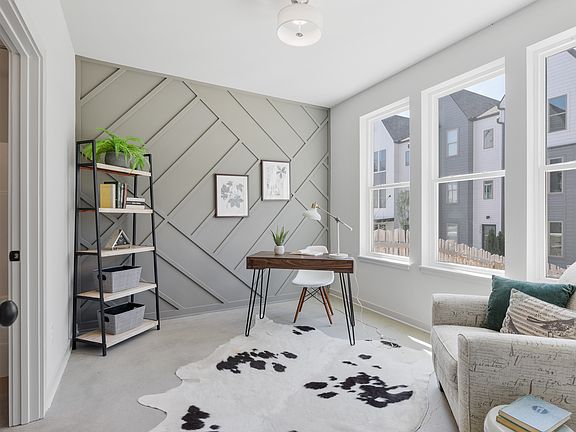 Sunlit first-floor bedroom with oversized windows and modern feature wall_currently styled as an office, but fully sized to accommodate a queen bed and more.