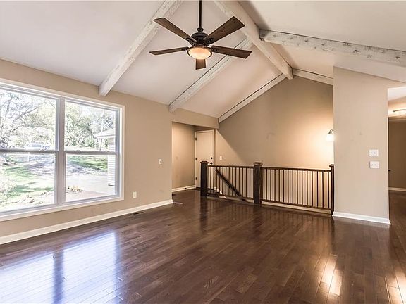 Grand entry area with vaulted ceilings, smooth ceilings throughout home, and custom barnwood and iron handrail. Hall to bedrooms