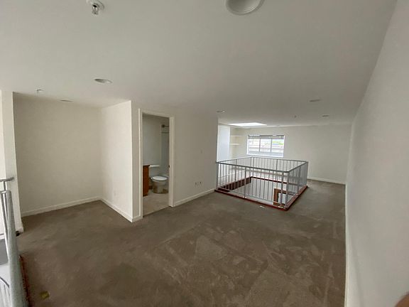 Lofted bedroom, a nook for a desk or bookcase, rear view window, and a functional skylight