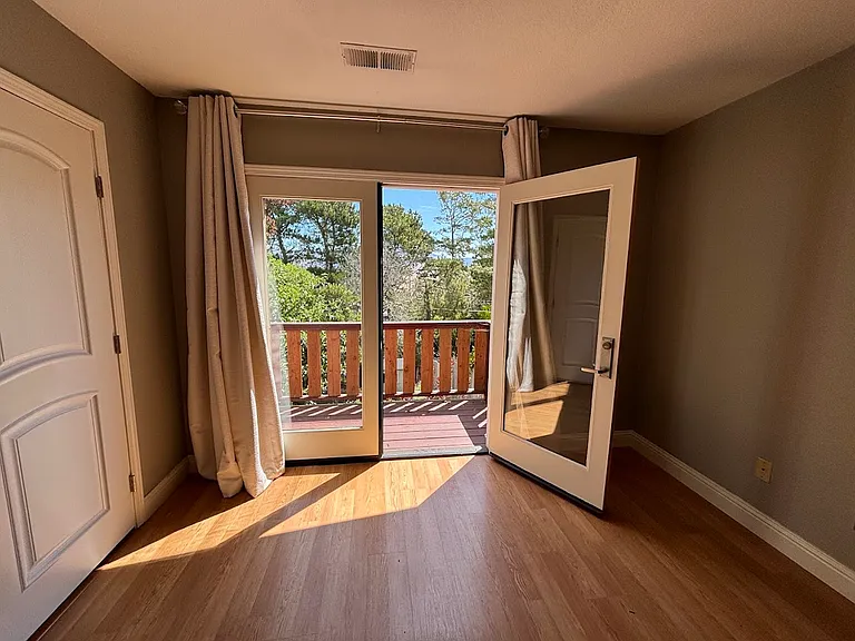 Primary bedroom double doors to private deck