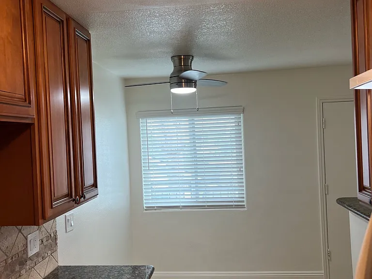kitchen facing dining with wood cabinets, granite counters, stove, new hood vent fan, refrigerator