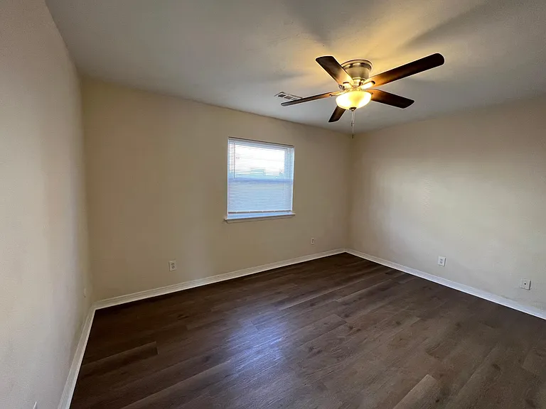 Bedroom with ceiling fan and ensuite bathroom.