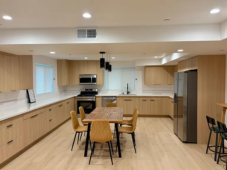 Spacious U-shaped kitchen with ample cabinetry, generous counters, and stainless appliances plus a dining table.