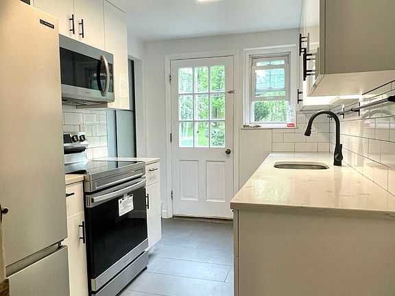 modern kitchen with newly remodeled cabinets, quartz counter tops, and stainless steel appliances.