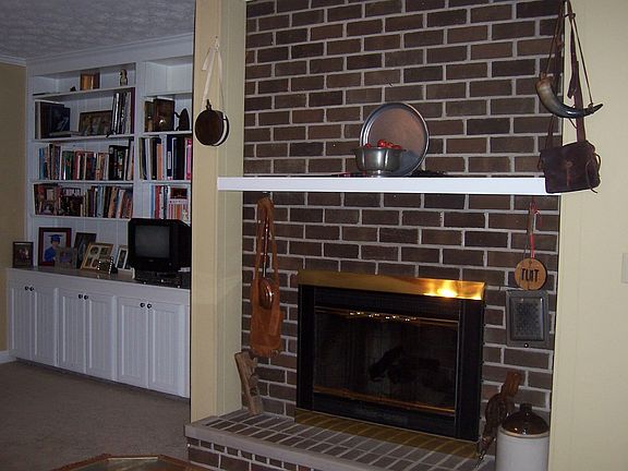 Den with gas logs and built-in shelving