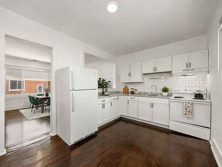 A sleek, updated kitchen featuring ample cabinet space and a bright, open layout that connects seamlessly to the dining area for easy entertaining. Image is virtually staged