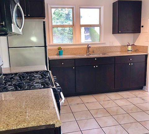 eat-in kitchen with espresso wood cabinets & granite counter