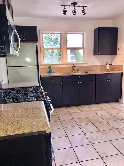 eat-in kitchen with espresso wood cabinets & granite counter