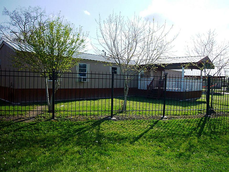 Front of home with black iron fence.