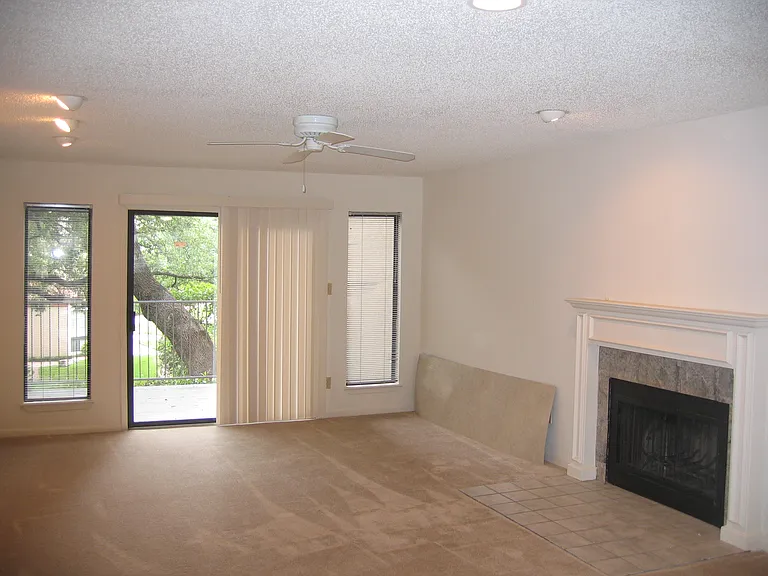 Spacious living room leading to tree-shaded deck