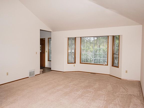 Light-filled living room with cathedral ceiling and large bay window.
