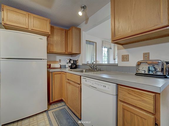 Lovely cabinets, white appliances. The formal dining room is accessed to the left and the opening over the sink looks into the casual eating area. 