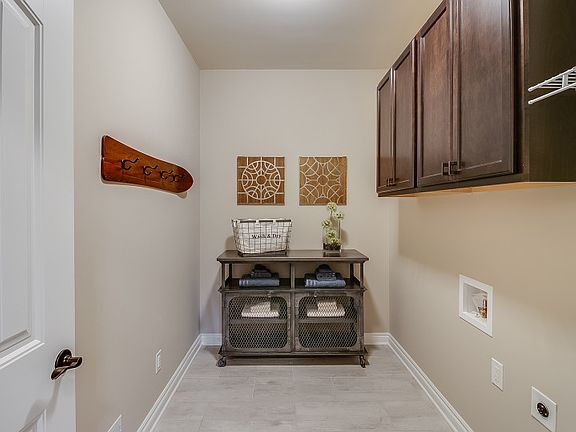 Large Laundry Room with upper storage cabinets and wall shelving.