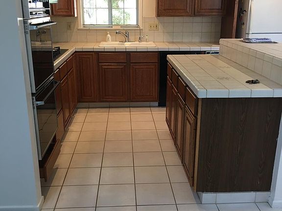 Kitchen boasts double ovens, a gas range, new dishwasher and refrigerator, water dispenser, an island with extra counter space and cabinets
