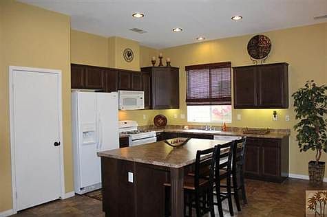 Beautiful kitchen with plenty of cabinets, pantry for extra storage. Hardware accents on dark cabinetry finish off the decorator look in this ease of living kitchen!