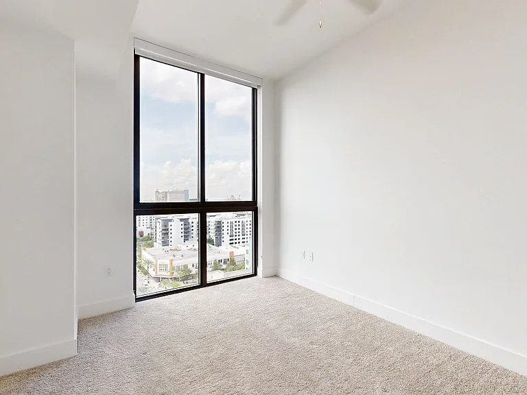 Spacious apartment bedroom with carpet flooring.