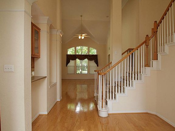 Inviting entry way with high ceilings and a glimpse into the Den with vaulted ceilings.
