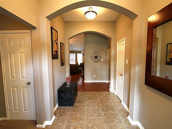 Entrance view showing inviting archways, warm paint tones and updated light fixtures.