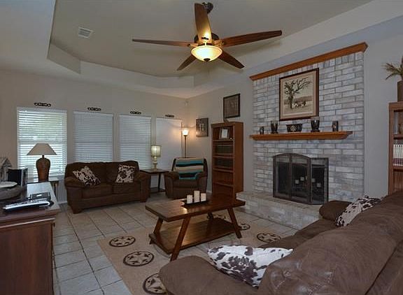 Family room with loads of windows, a cozy fireplace and easy to maintain tile floors.