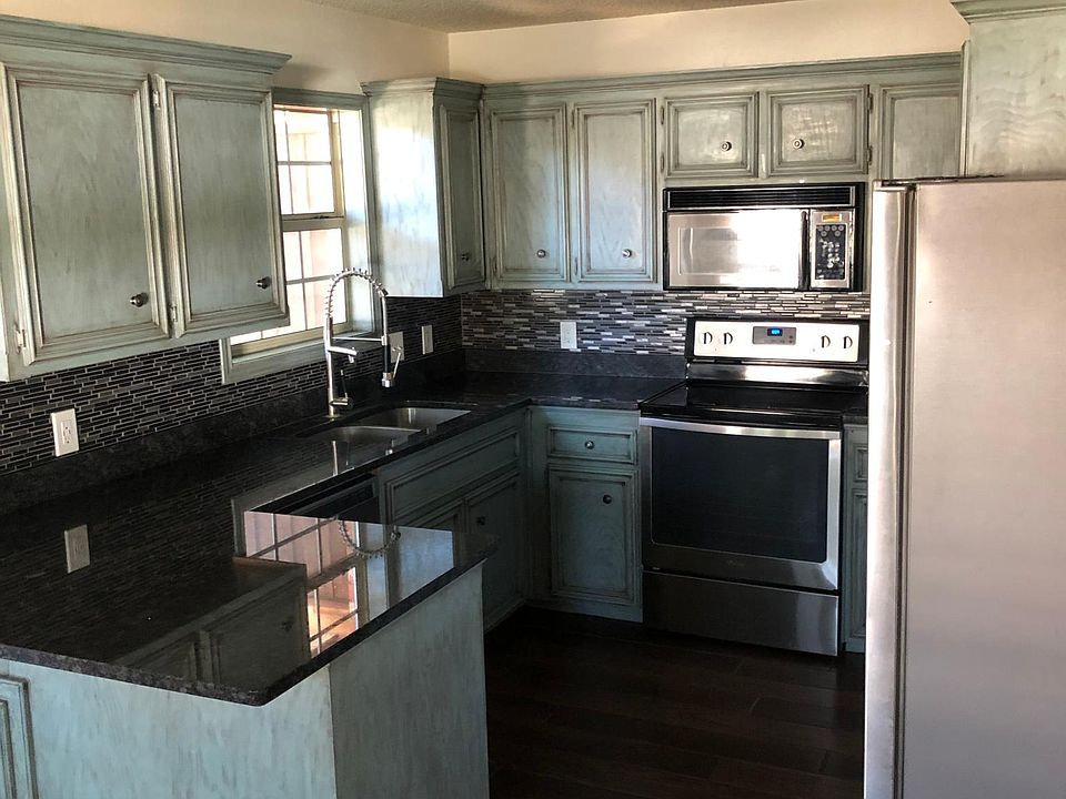 Beautifully renovated kitchen with new appliances, granite countertops and wood-look tile flooring