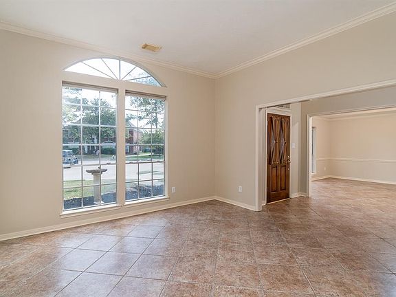 A traditional home with architectural details including arched windows, crown molding and large picture windows that allow the natural light to flow into the space!