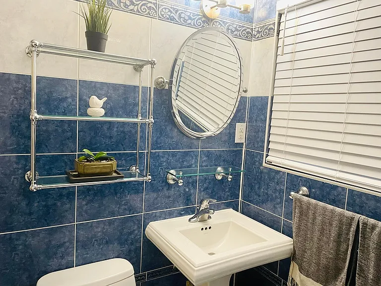 Full bathroom with bathtub and glass shelves. New blinds throughout the house.