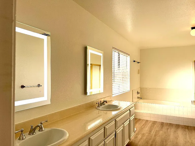 Master Bath with new cabinets, wood floors, paint, and mirrors. 
Double sinks, bath, and shower.