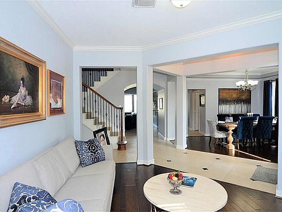 Lovely open floor plan features custom tilework and wrought-iron stairail.