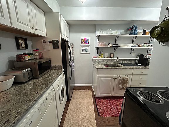 Kitchen with regriderator, electic stove, microwave, and garbage disposal