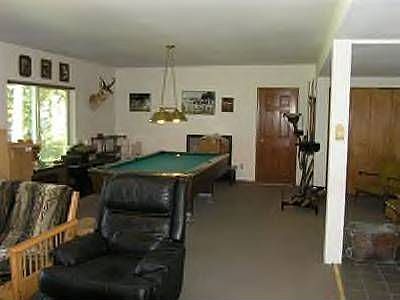 Large finished rec room with fireplace opens to concrete patio below.
