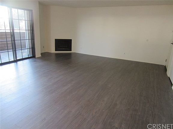 New laminate floors in huge living room with dining area and gas fireplace.