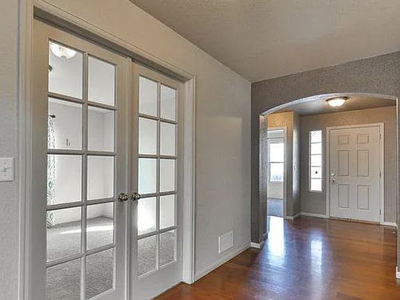 Entry way, 2nd bedroom in distance, office w/ french doors