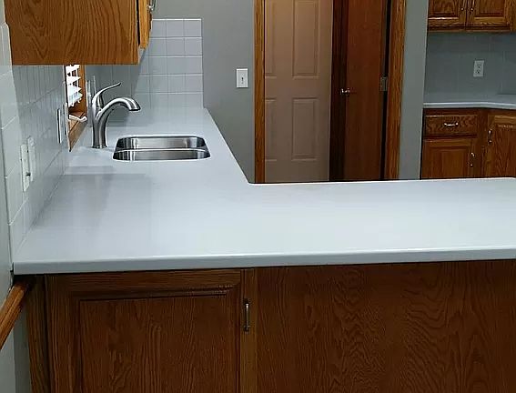 Corian counters in kitchen with tiled backsplash