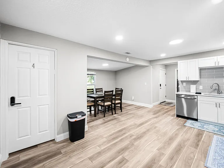 Open kitchen with ample cabinetry, subway-tile backsplash, dishwasher, and an adjacent dining area for shared meals.
