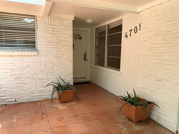Inviting front tiled entry porch looking towards front door and living room windows.