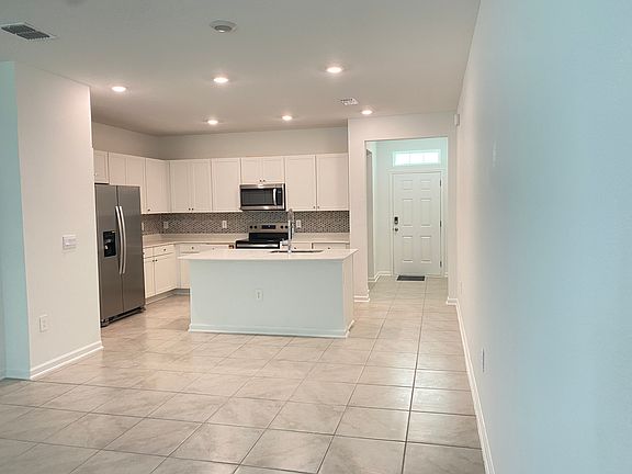 Dining and Kitchen with tiled backsplash, walk in pantry and large island.