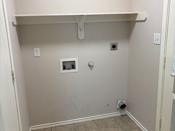 Indoor laundry room, door on the left to the garage, door on the right to backyard area.