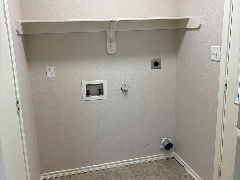 Indoor laundry room, door on the left to the garage, door on the right to backyard area.
