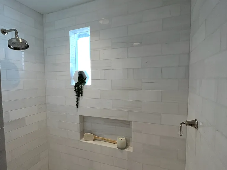 Downstairs guest bathroom with dual shower heads along with a hand held shower. An overhead rain shower is perfect for teens and adults, while the second shower is shorter for children and perfect for placing a teak bench underneath for grandparents.