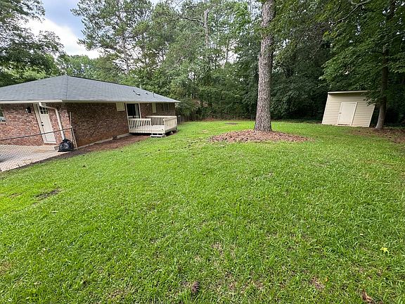 Large, fenced backyard with large storage building.