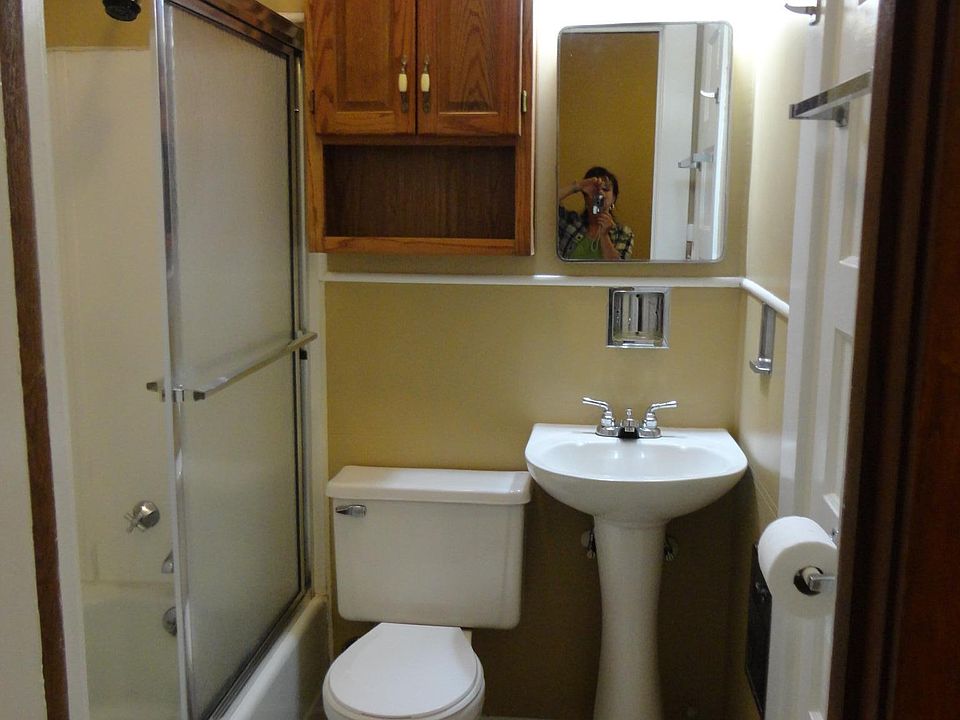 Small bathroom with linen closet, bathtub & shower with glass shower doors.